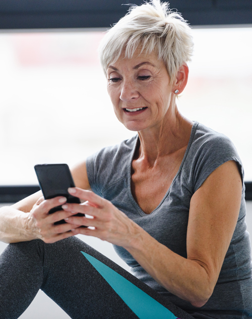 Excited woman scheduling her next online training session with OneUp.